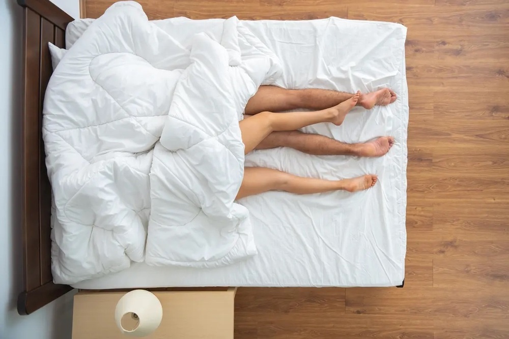 мужчина и женщина лежат на кровати под одеялом